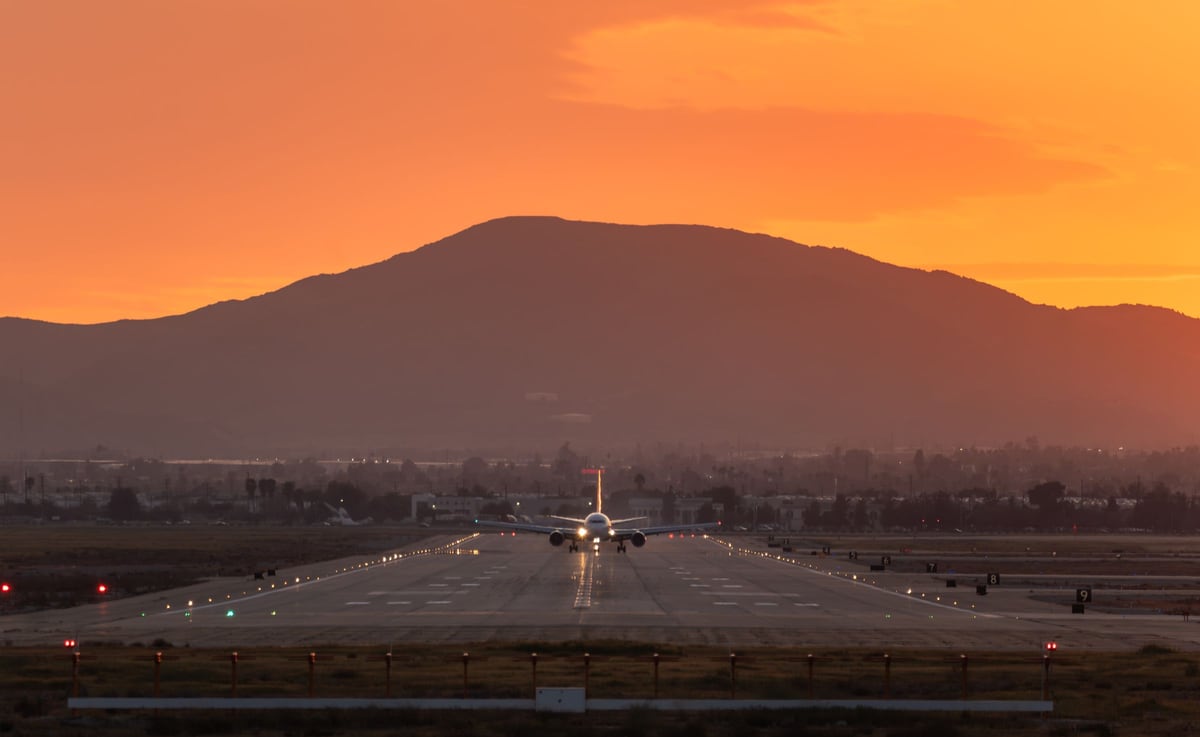 Aircraft on a runway beneath a golden sunset